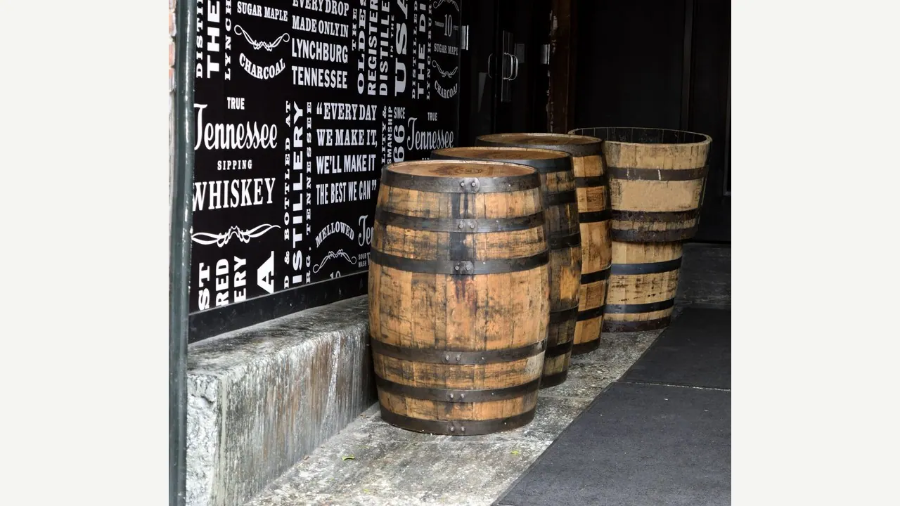 Botti di legno per l'invecchiamento del whisky allineate in un magazzino